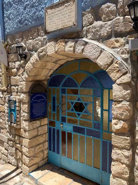 The stone facade and blue gate of the Bas Ayin (Avritch) shul in Tzfas